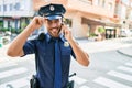 Young handsome hispanic policeman wearing police uniform smiling happy