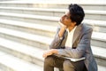 Young handsome Indian man in an office suit and white shirt sitting on the steps