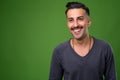 Young handsome Iranian man with mustache against green backgroun Royalty Free Stock Photo