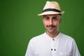 Young handsome Iranian man with mustache against green backgroun Royalty Free Stock Photo