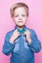 Young handsome kid smiling with blue shirt and butterfly tie. Studio portrait over pink background Royalty Free Stock Photo