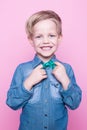 Young handsome kid smiling with blue shirt and butterfly tie. Studio portrait over pink background Royalty Free Stock Photo