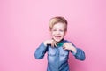 Young handsome kid smiling with blue shirt and butterfly tie. Studio portrait over pink background Royalty Free Stock Photo