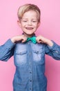 Young handsome kid smiling with blue shirt and butterfly tie. Studio portrait over pink background Royalty Free Stock Photo