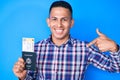 Young handsome latin man holding united states passport and boarding pass pointing finger to one self smiling happy and proud Royalty Free Stock Photo
