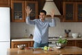 Young handsome Latin man move to music cooking in kitchen Royalty Free Stock Photo