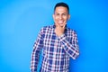 Young handsome latin man wearing casual clothes looking confident at the camera smiling with crossed arms and hand raised on chin Royalty Free Stock Photo