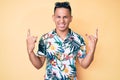 Young handsome latin man wearing summer clothes shouting with crazy expression doing rock symbol with hands up Royalty Free Stock Photo