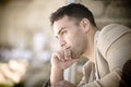 Young handsome leaning chin on hand looking pensive