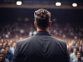 Young handsome life coach in elegant suit during presentation speech in front of the large audience, generated by AI Royalty Free Stock Photo