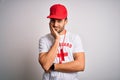 Young handsome lifeguard man with beard wearing t-shirt with red cross and whistle thinking looking tired and bored with