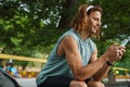 Young handsome long-haired smiling man using his phone Royalty Free Stock Photo