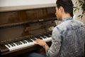 Young handsome male artist playing classical upright piano Royalty Free Stock Photo