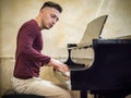Young handsome male artist playing classical piano