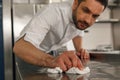 Close up of handsome male chef cleaning his workplace on kitchen in restaurant Royalty Free Stock Photo