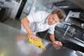 Young handsome male cook cleaning restaurant kitchen Royalty Free Stock Photo