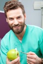 Young handsome male doctor smiling with white teeth holding apple Royalty Free Stock Photo