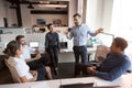 Millennial male leader working with diverse team at office.