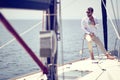 A young handsome male model is enjoying the sun and coffee at a photo shooting on a yacht on the seaside. Summer, sea, vacation Royalty Free Stock Photo