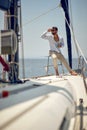 A young handsome male model at a photo shooting on a yacht on the seaside is enjoying the scenery. Summer, sea, vacation Royalty Free Stock Photo