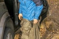 Young handsome male put on waterproof costume for hunting or fishing in cool autumn day b