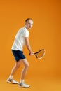 young handsome male tennis player plays tennis on yellow backgro Royalty Free Stock Photo