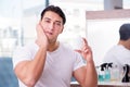 The young handsome man applying face cream Royalty Free Stock Photo