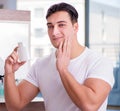 Young handsome man applying face cream Royalty Free Stock Photo