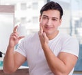 Young handsome man applying face cream Royalty Free Stock Photo