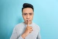 Young handsome man asking for silence and quiet, gesturing with finger in front of mouth, saying shh or keeping a secret Royalty Free Stock Photo