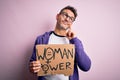 Young handsome man asking for women rights holding banner with woman power message serious face thinking about question, very Royalty Free Stock Photo