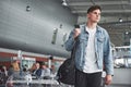 Young handsome man with a bag on his shoulder in a hurry to the airport.