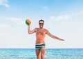 Young handsome man at the beach trowing the ball Royalty Free Stock Photo