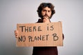 Young handsome man with beard asking for environment holding banner with earth message serious face thinking about question, very Royalty Free Stock Photo