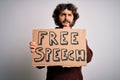 Young handsome man with beard asking for rights holding banner with free speech message serious face thinking about question, very Royalty Free Stock Photo