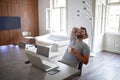 Young handsome man with beard and glasses, smiling, sitting, leaned back, relaxing, with laptop on table in front of him and two Royalty Free Stock Photo