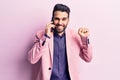 Young handsome man with beard having conversation talking on the smartphone screaming proud, celebrating victory and success very Royalty Free Stock Photo