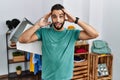 Young handsome man with beard holding shopping bags at retail shop crazy and scared with hands on head, afraid and surprised of Royalty Free Stock Photo