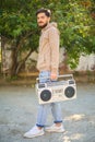 Young handsome man with beard holding vintage tape recorder Royalty Free Stock Photo