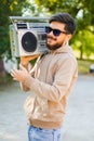 Young handsome man with beard holding vintage tape recorder Royalty Free Stock Photo