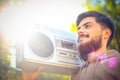 Young handsome man with beard holding vintage tape recorder Royalty Free Stock Photo
