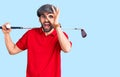 Young handsome man with beard playing golf holding club and ball smiling happy doing ok sign with hand on eye looking through Royalty Free Stock Photo