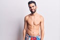 Young handsome man with beard shirtless wearing swimwear with a happy and cool smile on face