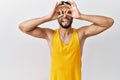 Young handsome man with beard standing over isolated background doing ok gesture like binoculars sticking tongue out, eyes looking Royalty Free Stock Photo