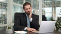 Competent businessman feeling toothache while working with laptop indoors