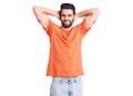 Young handsome man with beard wearing casual t-shirt relaxing and stretching, arms and hands behind head and neck smiling happy Royalty Free Stock Photo