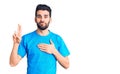 Young handsome man with beard wearing casual t-shirt smiling swearing with hand on chest and fingers up, making a loyalty promise Royalty Free Stock Photo