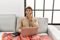 Young handsome man with beard wearing operator headset working from home bored yawning tired covering mouth with hand Royalty Free Stock Photo