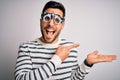 Young handsome man with beard wearing optometry glasses over isolated white background amazed and smiling to the camera while Royalty Free Stock Photo