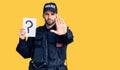 Young handsome man with beard wearing police uniform holding question mark with open hand doing stop sign with serious and Royalty Free Stock Photo